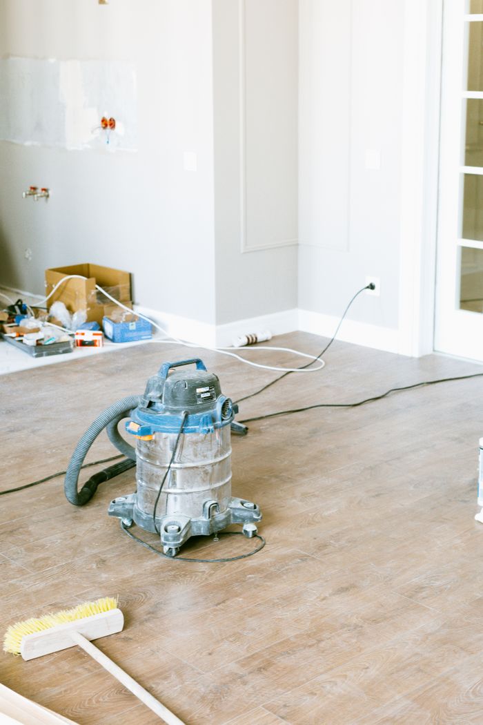 about-us-01 A vacuum and tools in a room undergoing renovation, highlighting home improvement.
